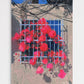 Artistic depiction of red flowers behind a wire fence with a blue sky.