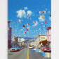 City street scene with colorful balloons and buildings under a blue sky.