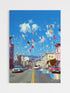 City street scene with colorful balloons and buildings under a blue sky.