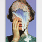 Artistic portrait with colorful headpiece and blue flower against a purple background