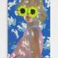 Person wearing a floral headband against a blue sky with white clouds