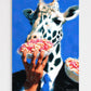 Giraffe eating a piece of pizza held by a hand against a blue background