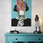 Colorful abstract painting of a face on a blue wall above a teal console table with decorative items.