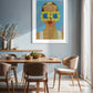 Dining room with a framed artwork on the wall, featuring a person with flowers covering their eyes.