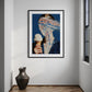 Framed artwork of a person with ice cream on a wall in a room with a vase on the floor.