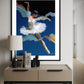 Framed abstract artwork of a dancer on a wall above a side table with decor items.