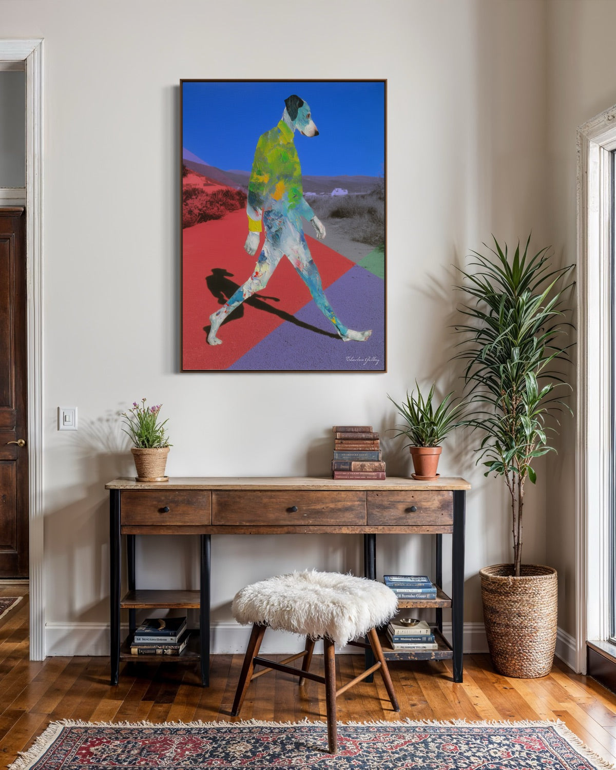 Colorful abstract painting on a wall above a wooden console table with decor items.
