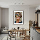 Modern kitchen with a dining table and chairs, featuring a framed artwork on the wall.