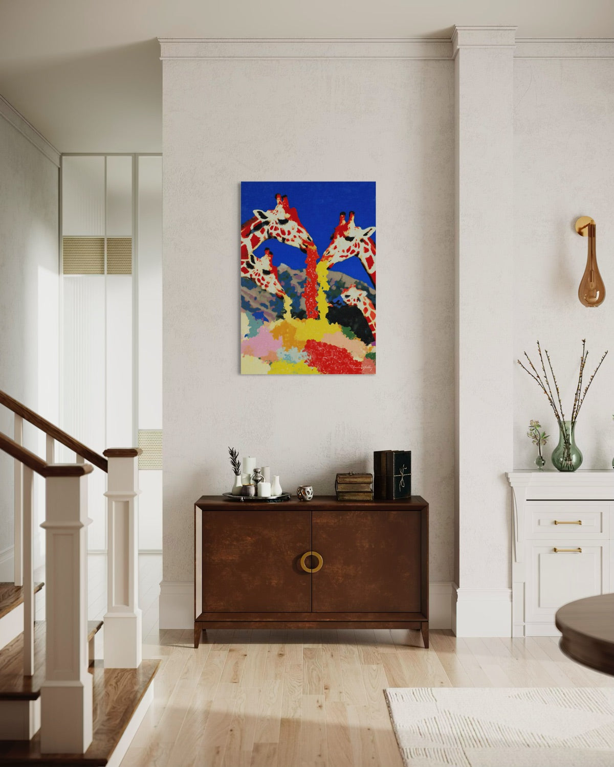 Colorful abstract painting of giraffes on a wall above a wooden cabinet in a room with a staircase.
