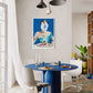 Dining room with a blue table, white chairs, and a colorful painting on the wall.