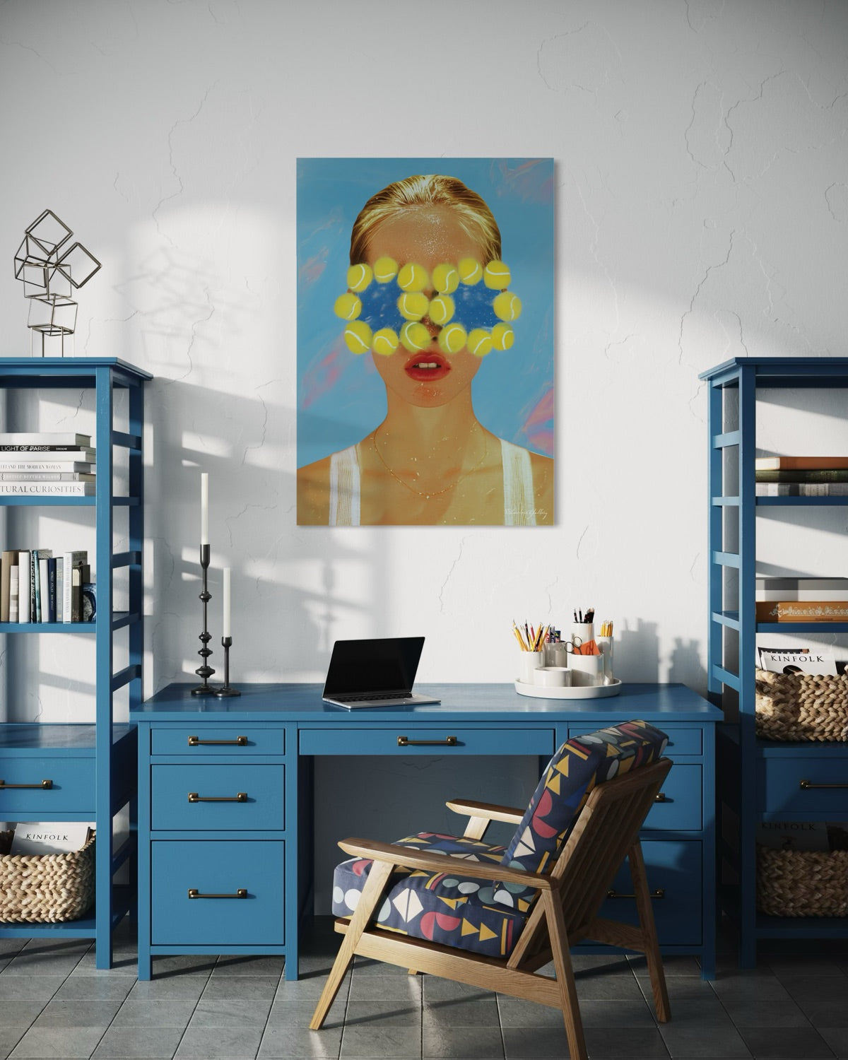 Modern home office with blue desk, chair, and shelves, featuring a colorful painting on the wall.