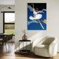 Modern living room with a white armchair, round table, and a colorful ballet dancer painting on the wall.
