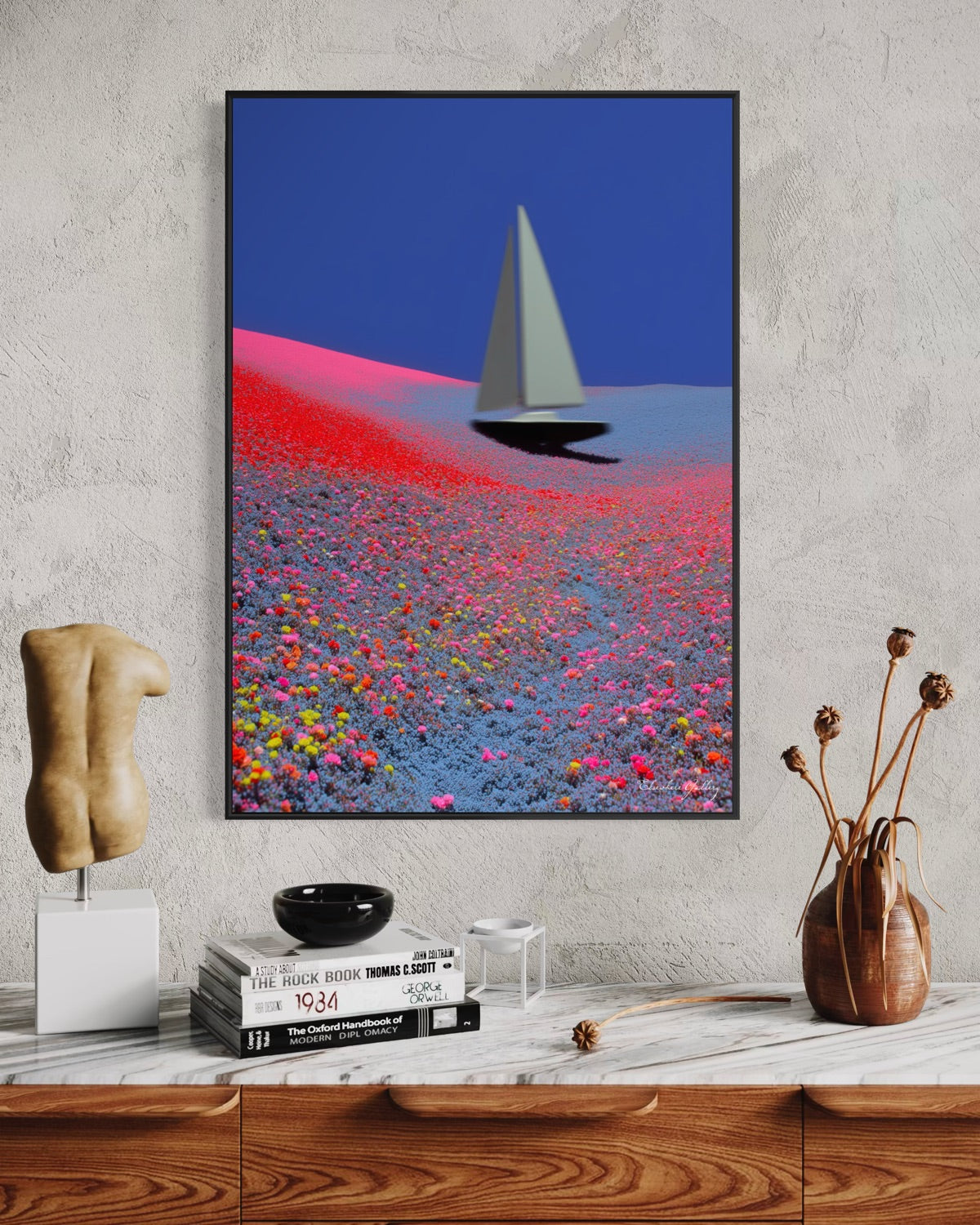Framed abstract art piece on a wall above a wooden shelf with decorative items.
