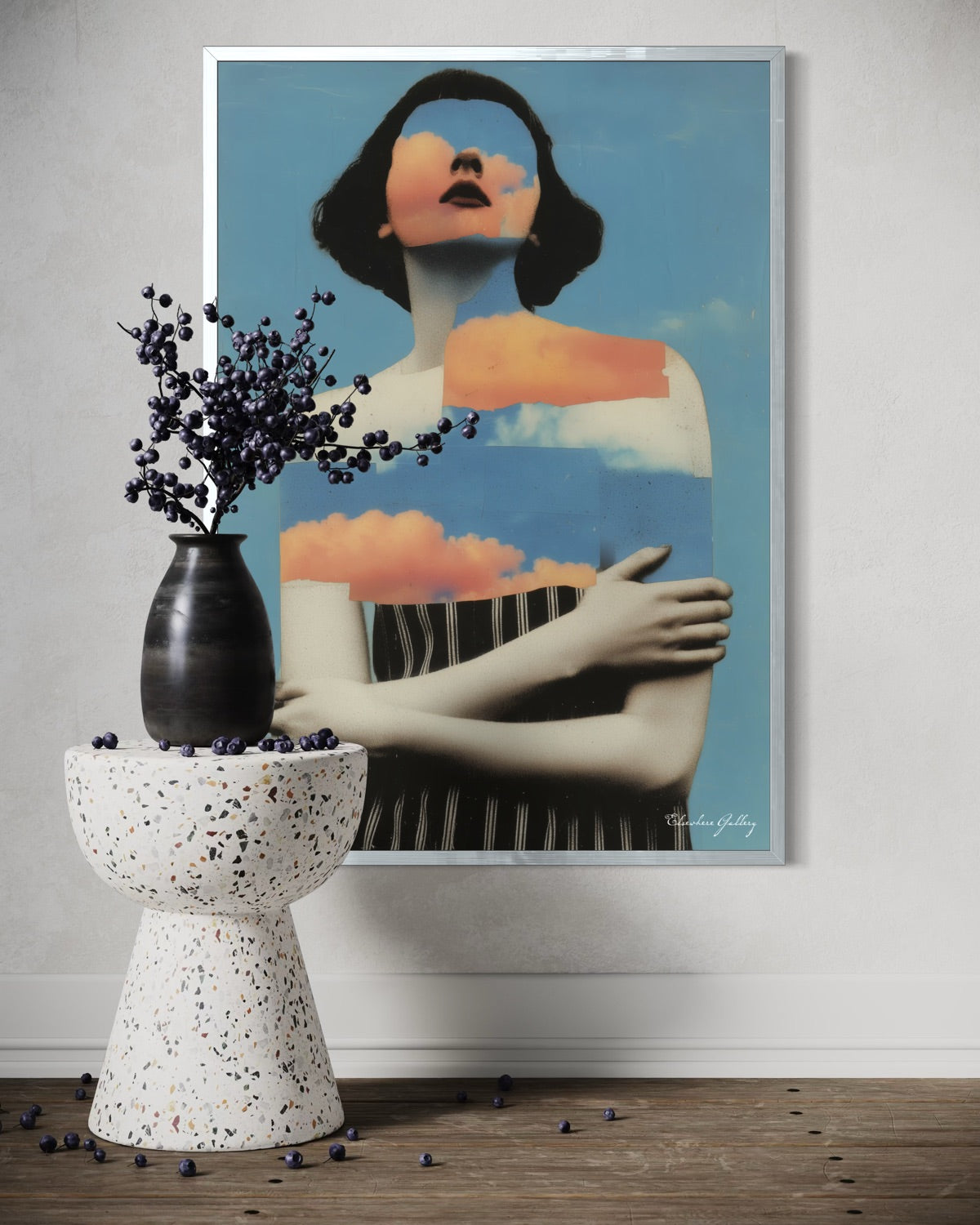 Framed artwork of a stylized woman with a vase and decorative elements on a table.