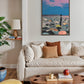 Living room with a beige sofa, wooden coffee table, and colorful abstract painting on the wall.