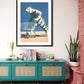 Framed artwork of a tiger pushing a shopping cart on a teal console table with decorative items.