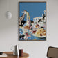 Framed artwork of a giraffe in a scenic setting on a wall above a table with a chair.