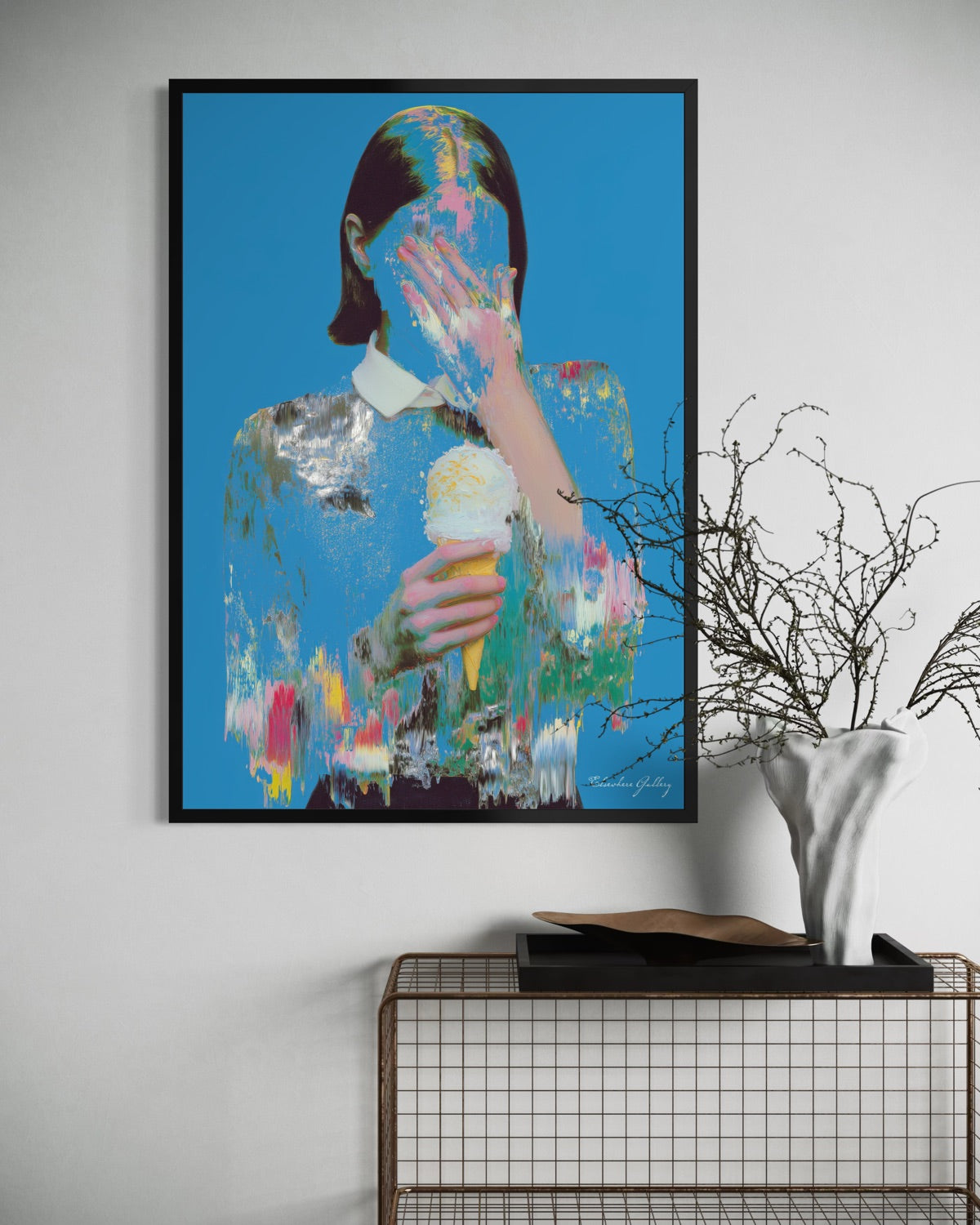 Framed abstract artwork of a person with an ice cream cone on a white wall.