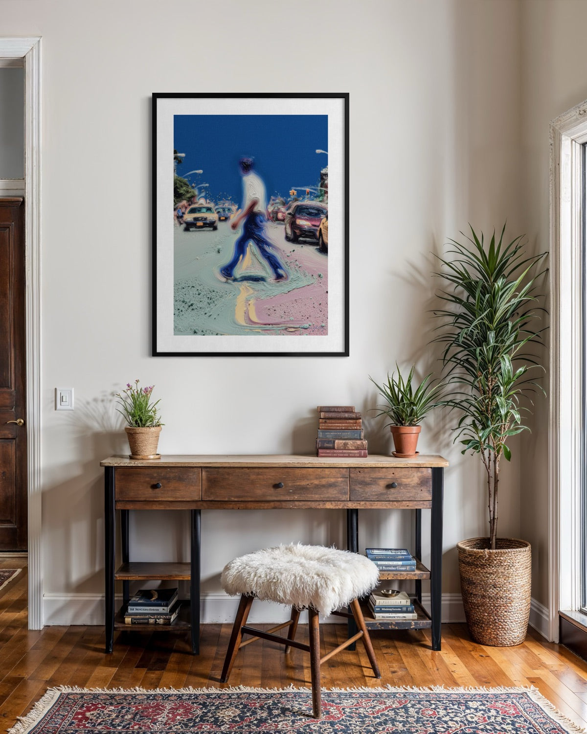 Framed artwork above a wooden console table with decorative items in a room.