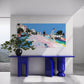 Modern interior with a blue console table, plant, and colorful painting on a white wall.