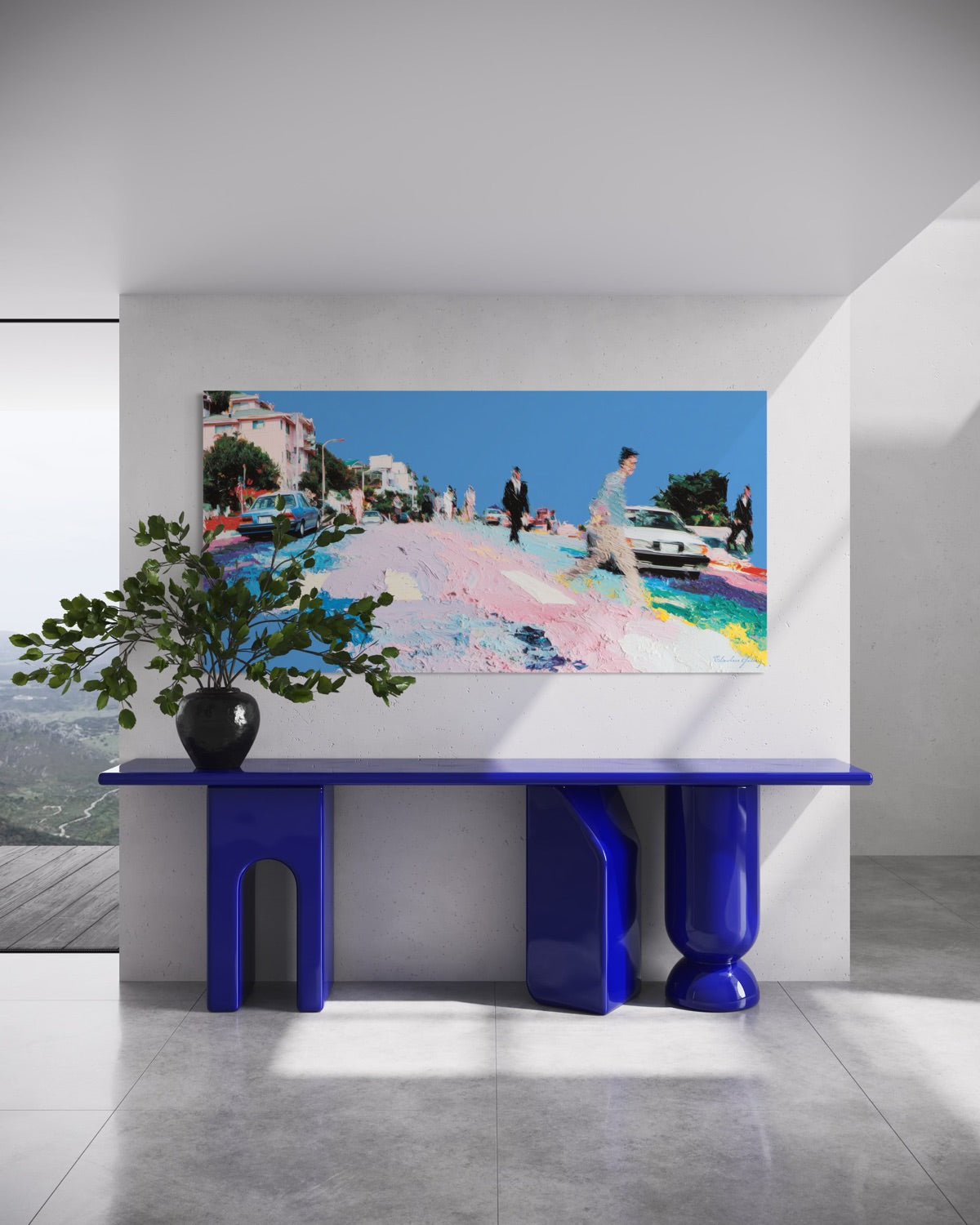 Modern interior with a blue console table, plant, and colorful painting on a white wall.