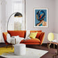 Modern living room with orange sectional sofa, yellow rug, and decorative wall art.