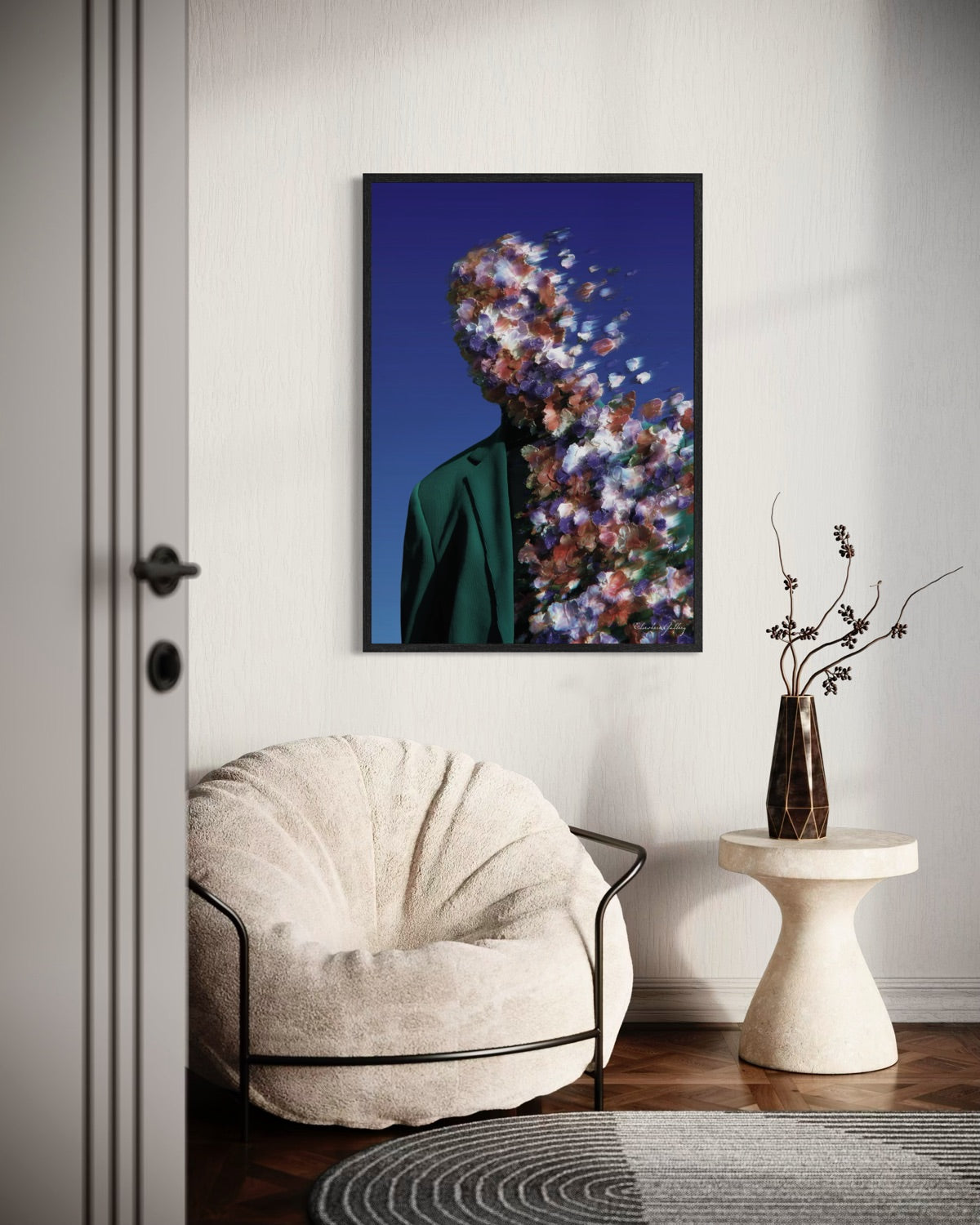 Framed artwork of a person with flowers superimposed on their face above a beige armchair.