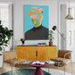 Modern living room with yellow cabinet, brown chairs, and colorful artwork on the wall.