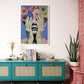 Colorful abstract art piece on a wall above a teal console table with decorative items.