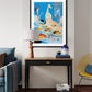 Framed artwork above a console table in a living room setting.