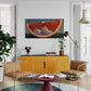 Modern living room with yellow cabinet, brown chairs, and a red table.