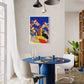 Dining room with a blue table, white chairs, and a colorful abstract painting on the wall.