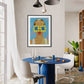 Modern dining room with a blue table, white chairs, and a colorful wall art piece.