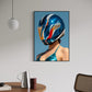 Framed artwork of a person wearing a colorful helmet on a wall above a table with a pitcher and cup.