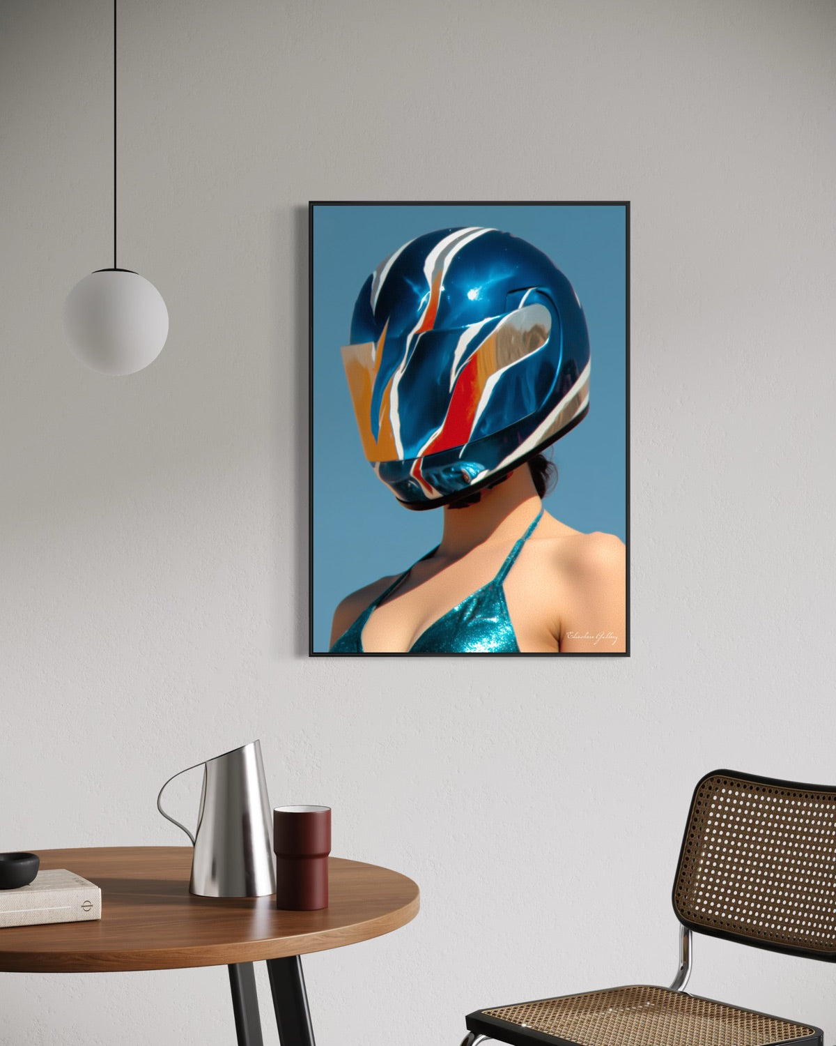 Framed artwork of a person wearing a colorful helmet on a wall above a table with a pitcher and cup.