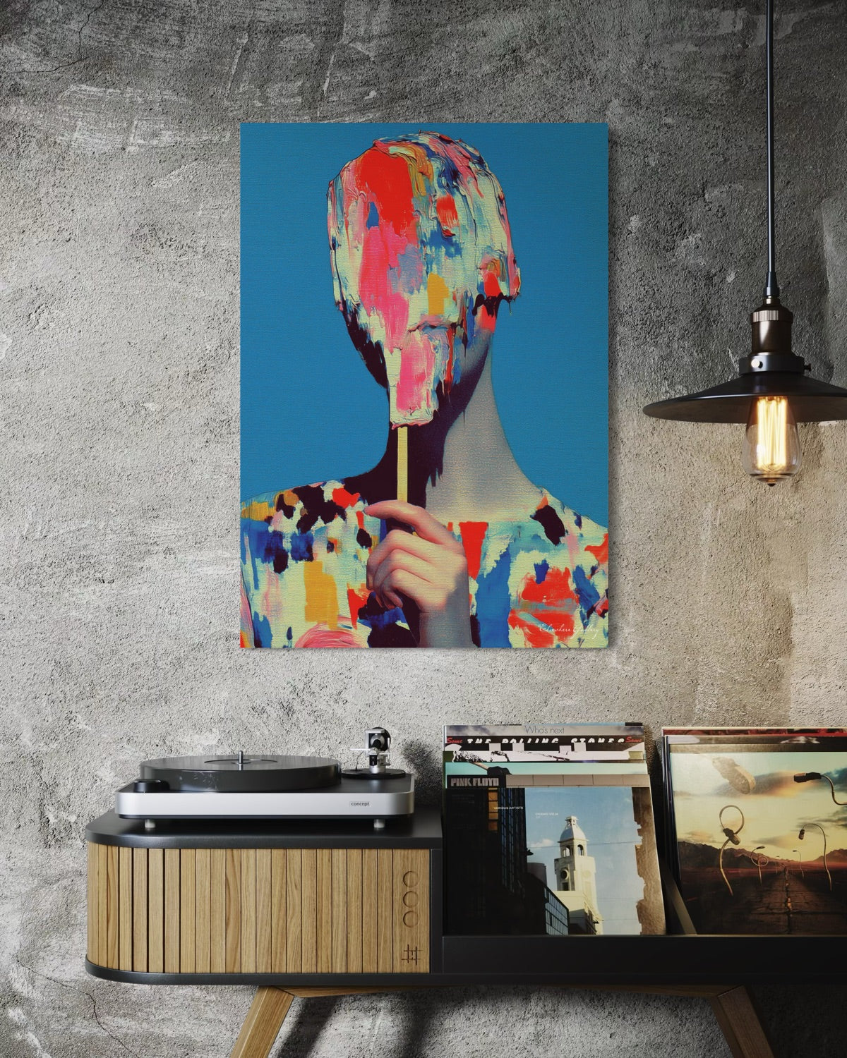 Abstract art painting of a colorful face on a blue background, displayed above a record player.