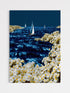 Surreal seascape canvas print showing sailboats navigating glowing blue waters and dense floral shores for modern home decor.